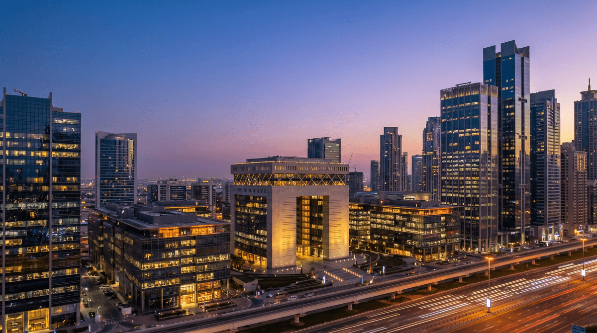 Dubai International Financial Centre and DIFC skyline at twilight, glass towers reflecting the city below.